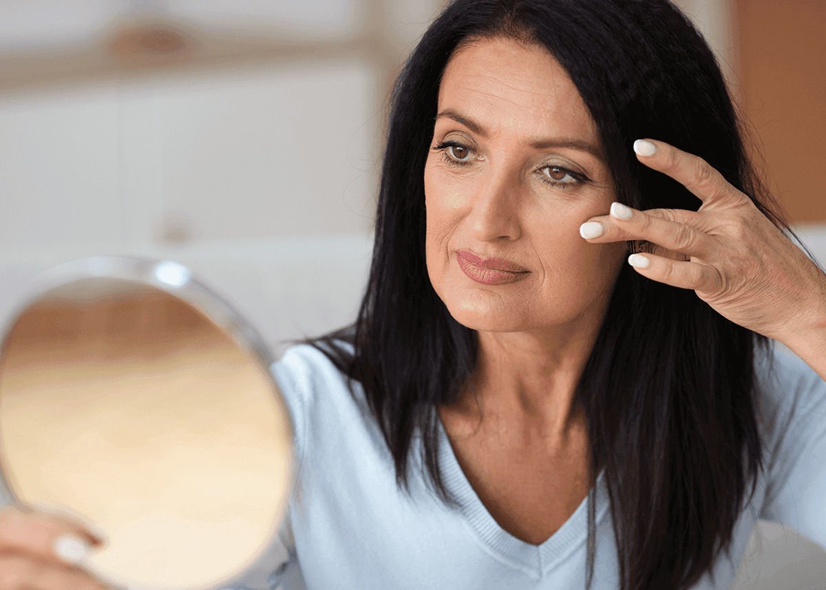 Woman looking in mirror and touching face