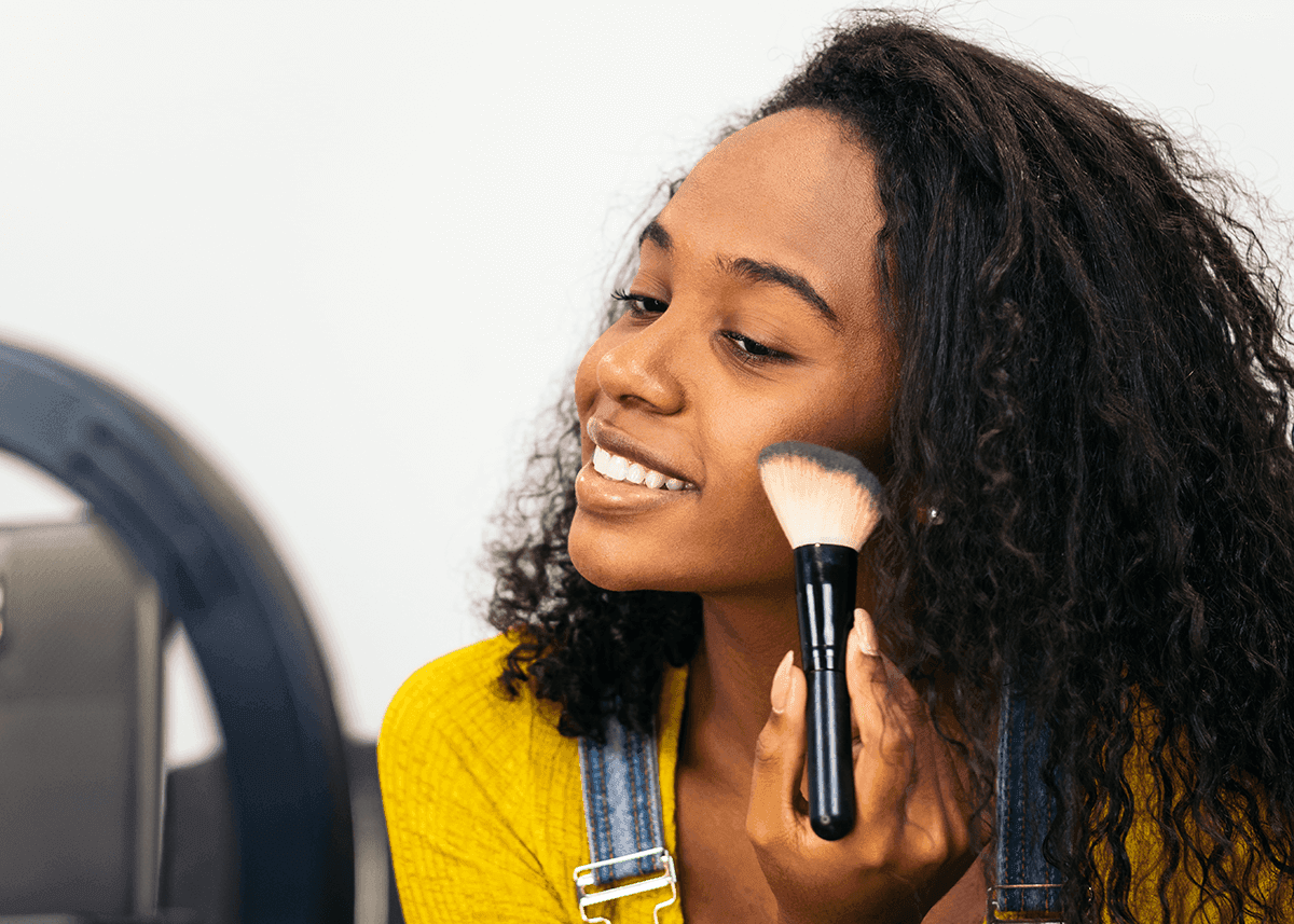 woman applying foundation to face