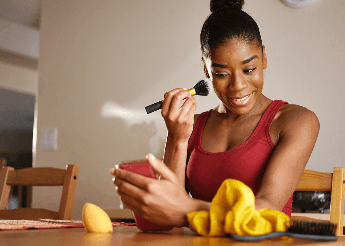 woman applying highlighter to face