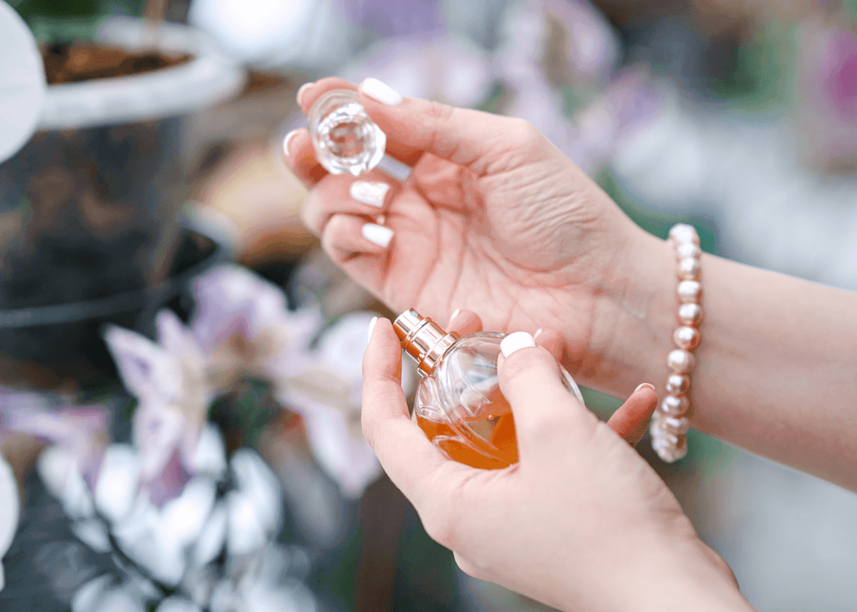 woman investigating open perfume bottle lid open