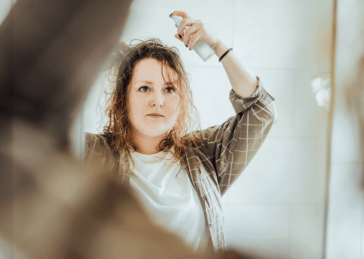 woman spraying hair touch up