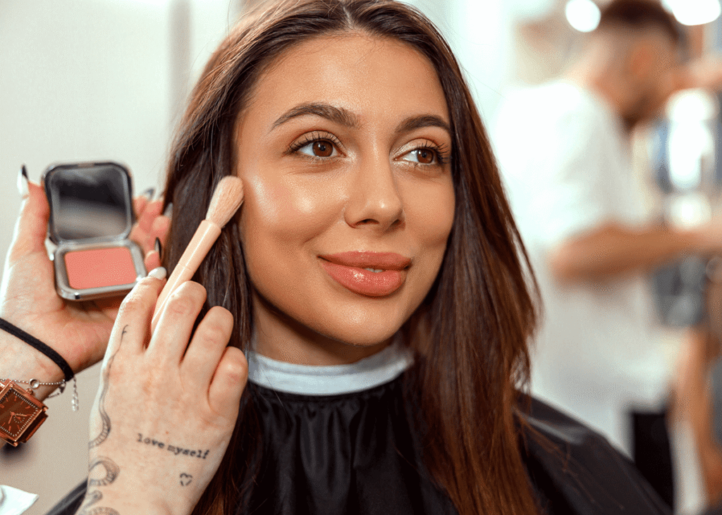 Smiling woman getting makeup done