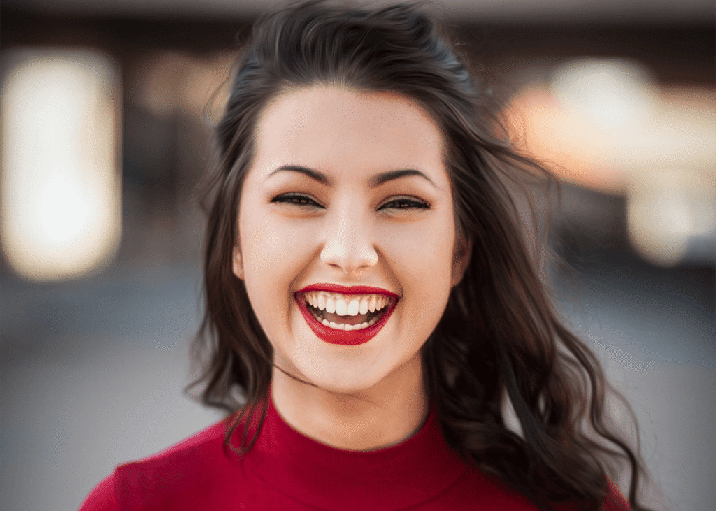 Young girl smiling bold red lip graduation makeup